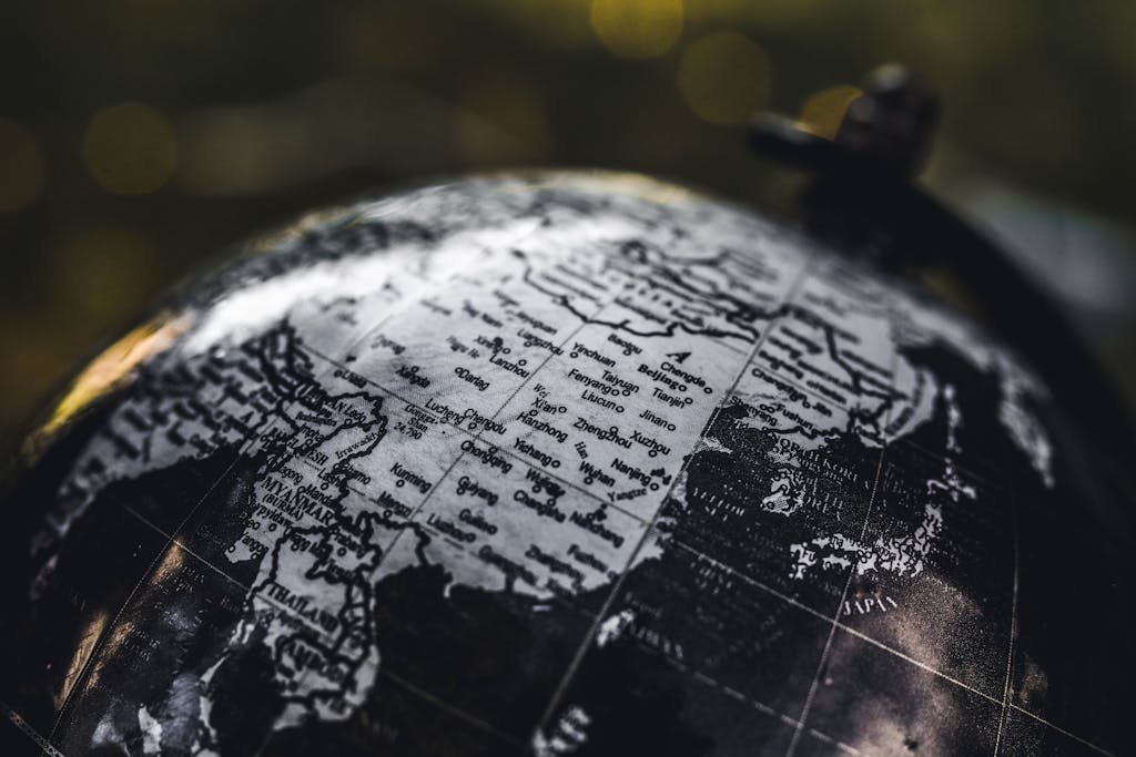 Detailed black and white close-up image of a globe focusing on Asia, highlighting geographical details.